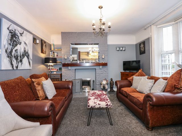 A living room with two brown sofas a fireplace and a television at 1 The Bays in Burgh Le Marsh