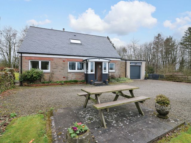 A house with a garage and table in the outdoor area at Falla Farmhouse in Jedburgh