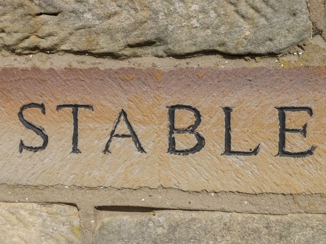 Stone wall with the word stable carved into a stone at Stable Cottage in Staintondale