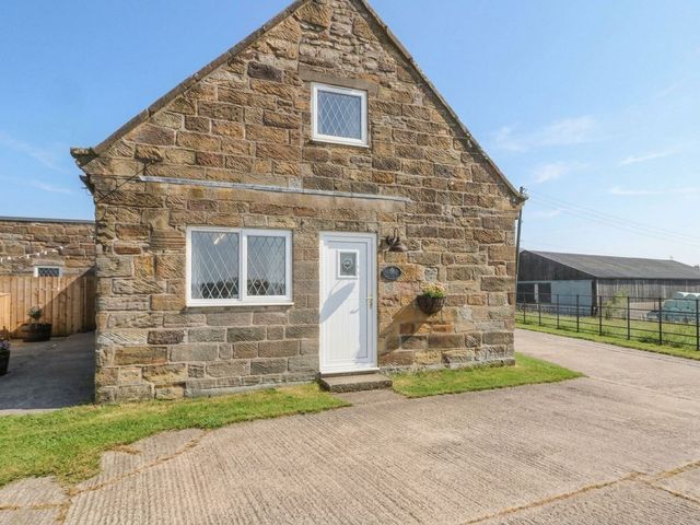 A stone building with a door and windows at Foxhunter Cottage in Hawsker near Whitby and Robin Hood's Bay