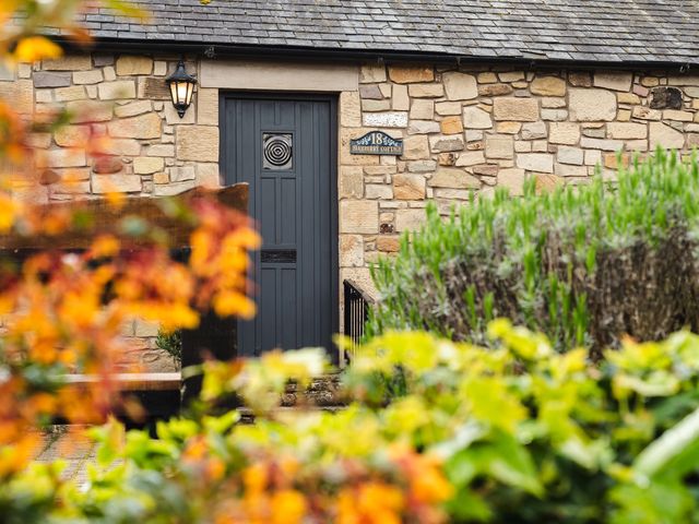 A door with a light fixture and sign at Blueberry Cottage in Akeld near Wooler