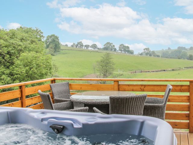 A balcony with a hot tub and outdoor furniture at Manor Farm Lodges - Red Kite Lodge in Newtown