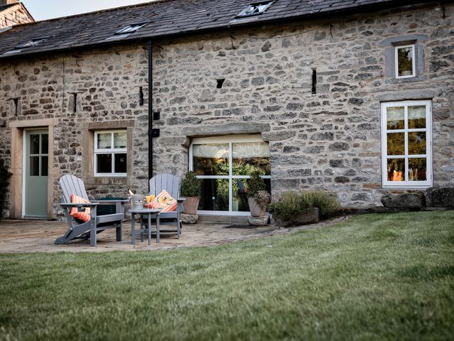 A patio area with chairs and a table at Carrholme Cottage Settle