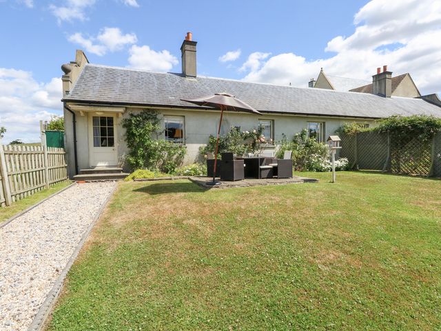 A garden with furniture and a parasol at Maple Cottage Buckland Newton near Dorchester