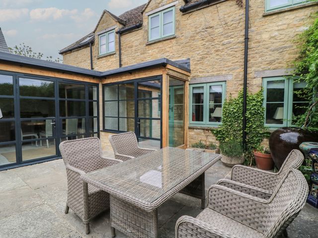 An outdoor seating area with a table and chairs at Fairview Cottage in Milton-Under-Wychwood
