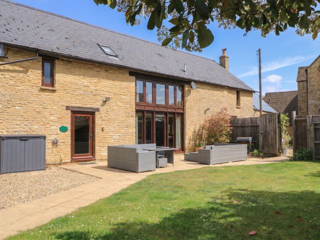 An outdoor area with seating and a garden at Tithe Barn, Lyneham