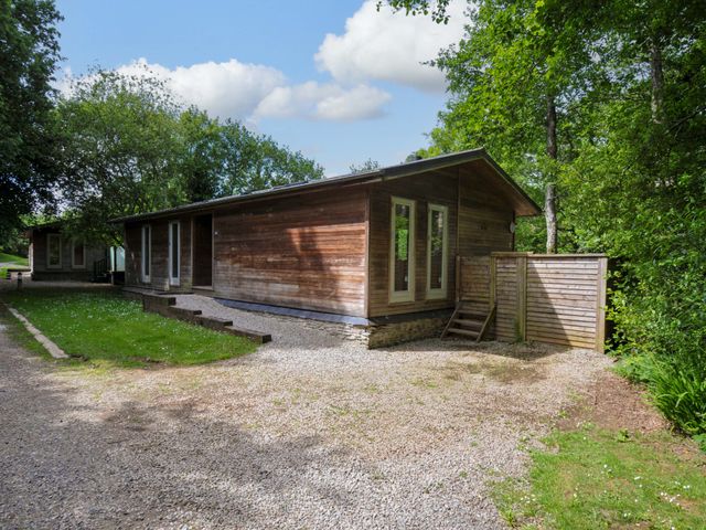 A wooden house with windows and a gravel path at 14 Stonerush Valley in Lanreath