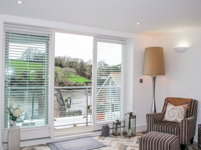 A living room with sliding doors and a lamp at Estuary View in Kingsbridge