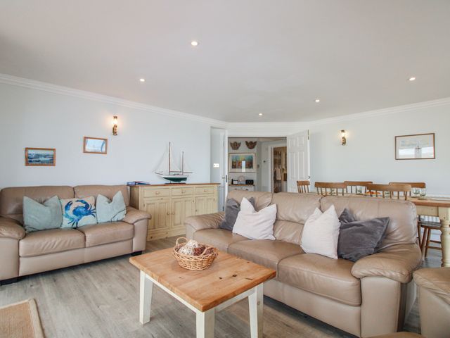 A living room with sofas and a table at 7 Thurlestone Rock in Thurlestone