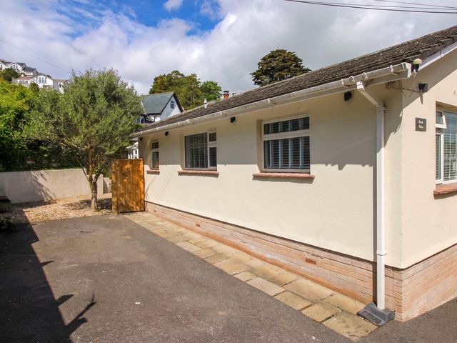 A house with a tree and fence at Rock Point in Salcombe