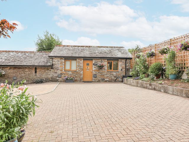 An outdoor area with a stone building and flower pots at Whitsand in Tideford