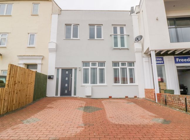 A front view of a two-story house with a gray door and windows with white blinds at 38 The Parade Walton-On-The-Naze