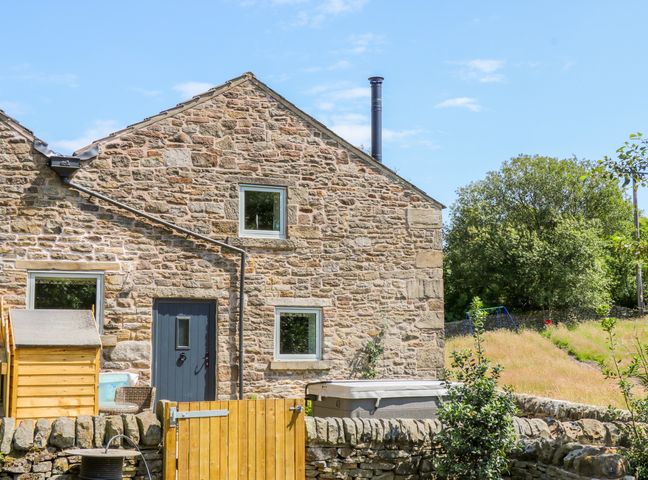Stone house with two windows door stone wall gate garden with trees and grass at Overlea Cowshed in Hayfield