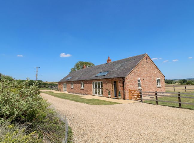 A house with a gravel driveway and garden at Teal Cottage in Melton Mowbray