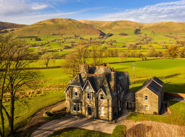 A country house with driveways surrounded by fields and hills at Oakdene Country House in Sedbergh