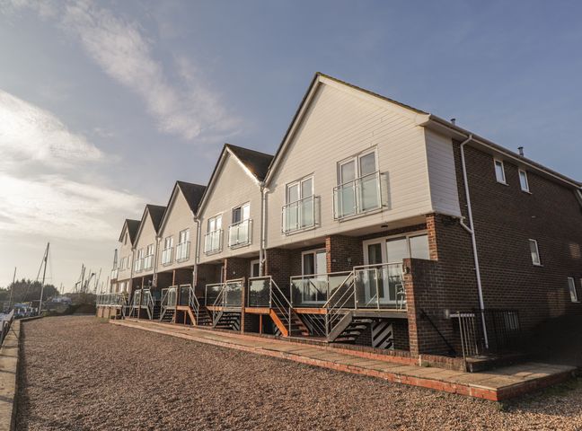 A row of modern townhouses with balconies by a waterfront at 7 Waves in Rye