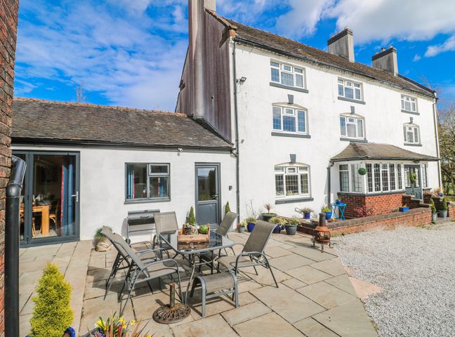 An outdoor patio with a table and chairs at Fields Farm in Cheadle