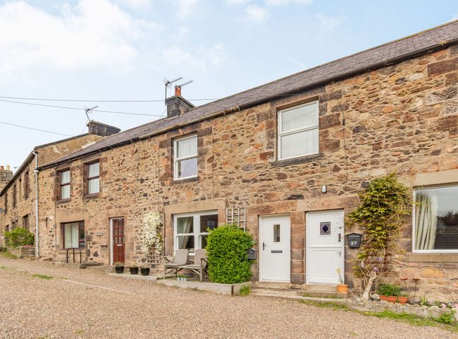 A row of stone terraced houses with white and brown doors and windows at Peth Head Cottage in Wooler