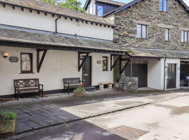 An outdoor area with benches and a stone wall at Ghyll Heights in Ambleside