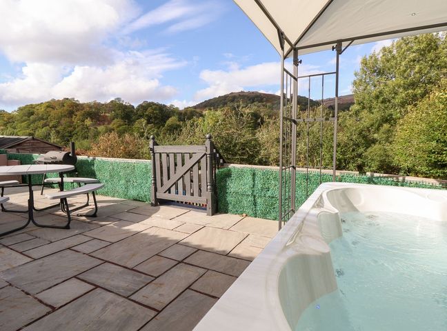 An outdoor area with a hot tub and patio furniture at Castellolwg