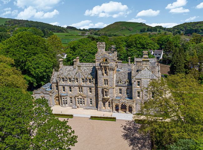 A large stone mansion surrounded by trees and hills at The Emma Suite Stone Cross Mansion in Ulverston