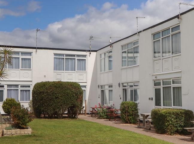 An outdoor area with buildings and bushes at Turtle Chalet in Dawlish Warren