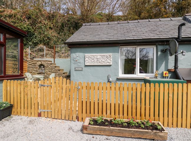 The exterior of a building with a wooden fence planter box and stone steps at The Nook Star near Cenarth