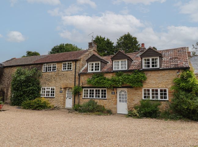 A house with multiple windows and a gravel path at The Old Bakery in South Perrott near Mosterton