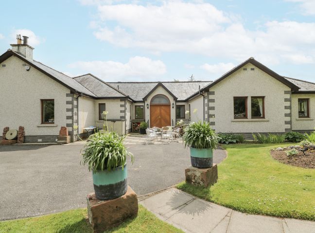 A house with a front door and seating area at Torview House Lyne Station near Peebles