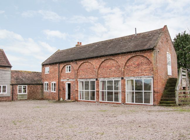 A large brick building with multiple windows and an external staircase at Stockbatch Granary in Shrewsbury