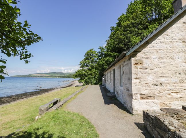 A stone building next to a coastal path with grass and trees by the sea at North Segganwell - Culzean Castle in Maybole