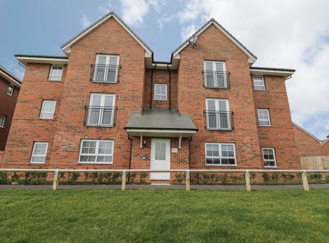 A brick apartment building with multiple windows and a white door at Valley View in Whitby