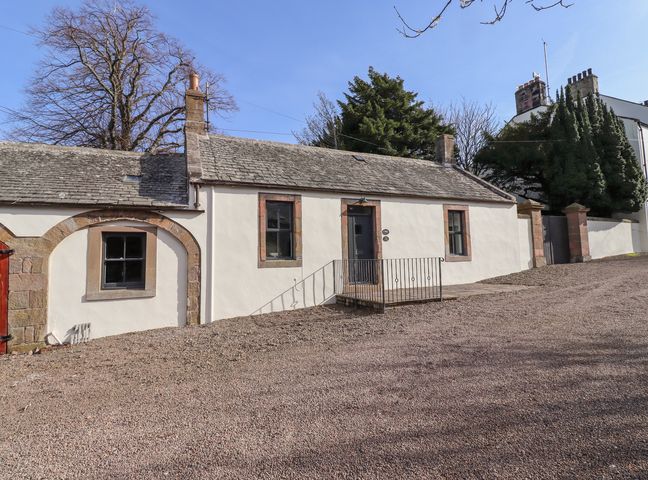 A single-story house with a gravel driveway and two windows at Manor Cottage Wooler