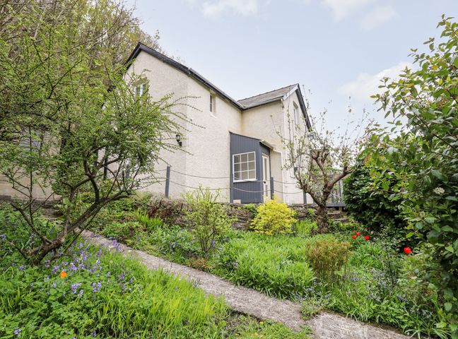 A house with a garden filled with various plants and trees at Myrtle Villa in Knighton
