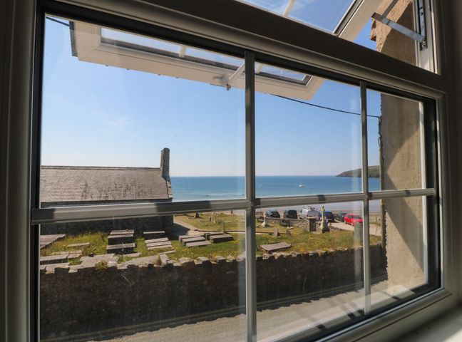 A view of the ocean and beach from a window at 4 Bryn Llan Aberdaron