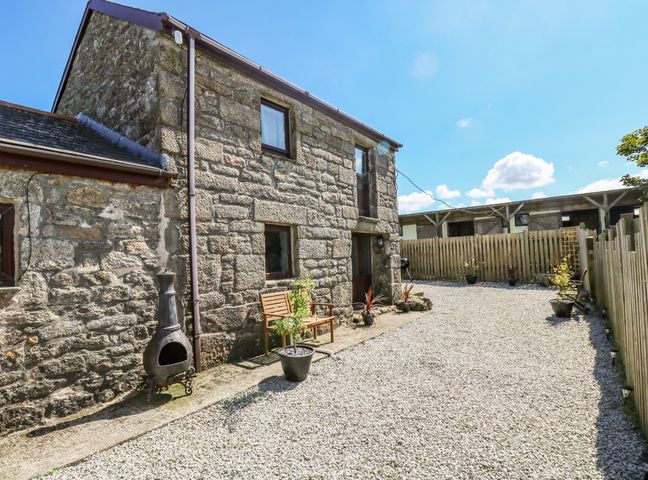 An exterior view of a stone building with a gravel driveway and potted plants at Polgear View Polgear Nr Redruth