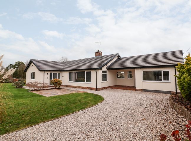 A single-story house with a gravel driveway and green lawn at Coedfan in Llanfwrog near Ruthin