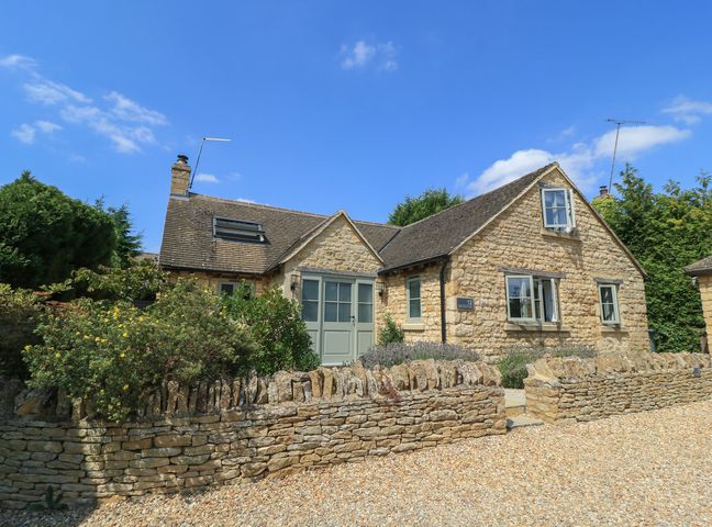 A house with stone walls and a gravel drive at 12 Manor Farm Close Kingham