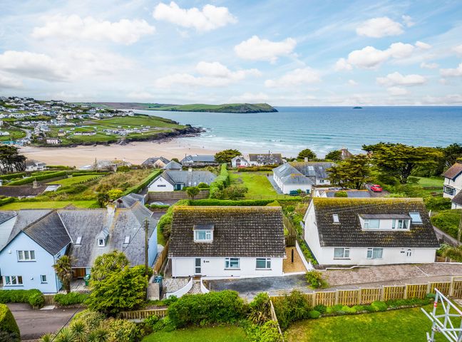 A coastal village with houses near a beach and ocean at Chy-An-Var in Polzeath
