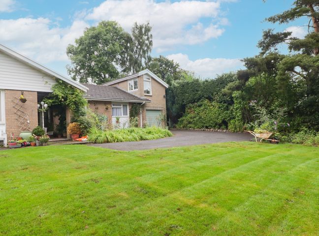 A house with a garden and driveway surrounded by trees and plants at Beacons Rest in Fennifach near Brecon