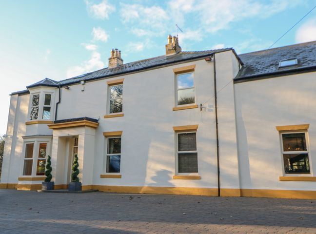Exterior view of a two-story house with white walls yellow trim and multiple windows at Glebe House in Dalton-le-Dale near Murton County Durham