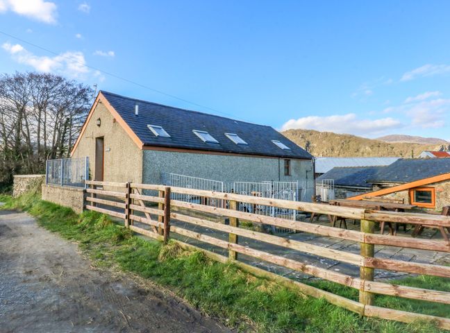 A building with a fence and pathway at Llofft Yr Yd Porthmadog