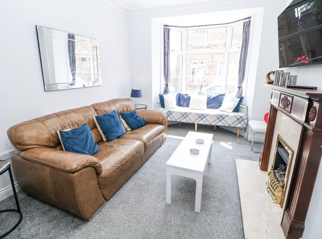 A living room with a sofa and coffee table at 15 South Avenue Mews in Buxton