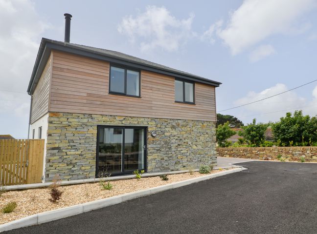 A two-story house with stone and wood exterior walls and a black-tiled roof at 3 Praa Cove in Praa Sands