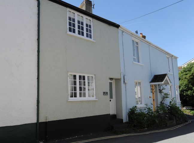 A street view of two adjoining houses one with a cream exterior and the other with a light blue exterior at 17 Mill Green Lyme Regis