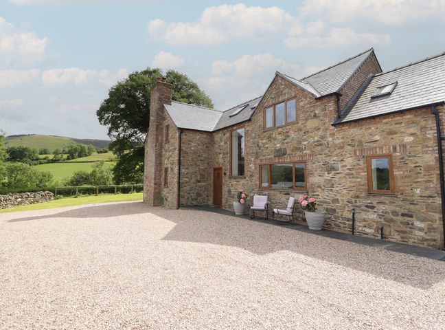 A house with windows and gravel area at Cwmwr Penybontfawr