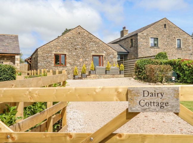 Stone cottages with wooden gate and gravel driveway at Dairy Cottage Thornton in Lonsdale near Ingleton
