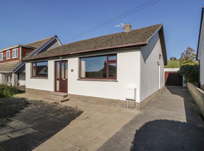 A single-story house with a driveway and garage at Marsh Garth in Kirkby-In-Furness