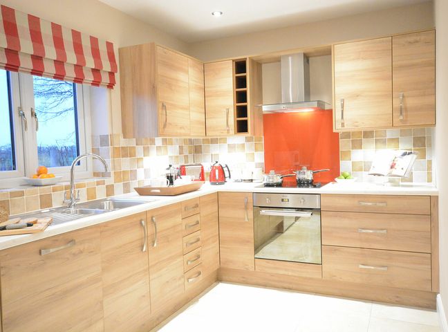 A kitchen with wooden cabinets a window and cooking utensils at Red Robin Whepstead in Wickhambrook near Bury St Edmunds
