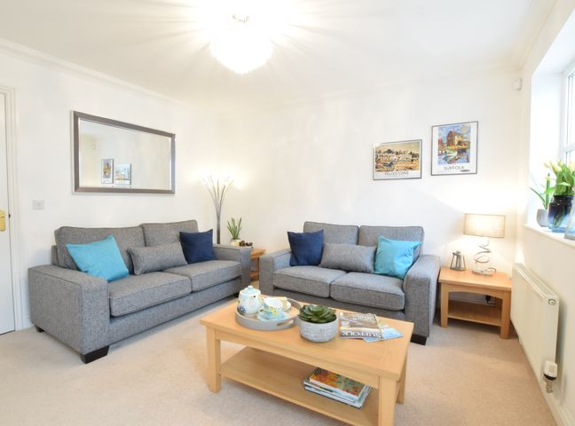 A living room with two gray sofas and a wooden coffee table at Bluebelle Cottage Peasenhall